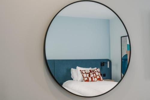 a mirror in a bedroom with a bed at voco Winchester Hotel & Spa by IHG in Winchester