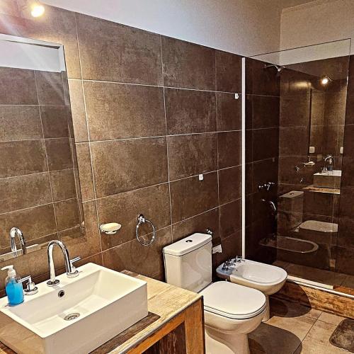 a bathroom with a sink and a toilet and a shower at Departamento Los Cardales in Los Cardales