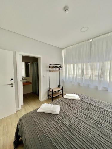 a bedroom with a large bed with two white towels at Solmar Alojamentos in Ponta Delgada