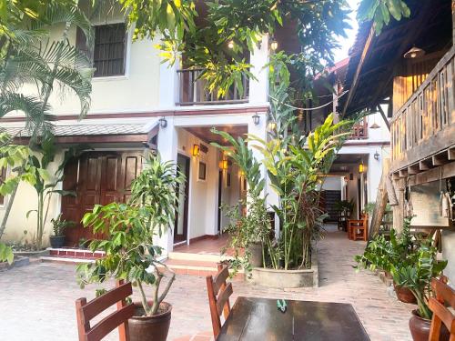 a courtyard of a building with benches and trees at Golden Sun Boutique Hotel in Luang Prabang