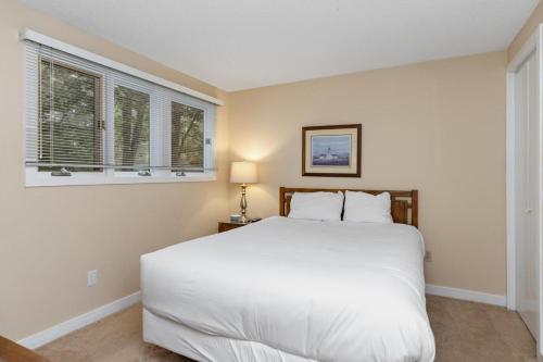 - une chambre avec un lit blanc et 2 fenêtres dans l'établissement Eagles Court 27 with Wintergreen Advantage, à Wintergreen