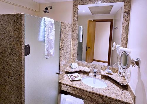 a bathroom with a sink and a mirror at Riale Vilamar Copacabana in Rio de Janeiro