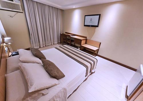 a hotel room with a bed and a desk at Riale Vilamar Copacabana in Rio de Janeiro