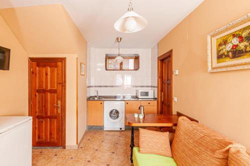 a living room with a table and a kitchen at Apartamentos la Regoria in Arenas de Cabrales