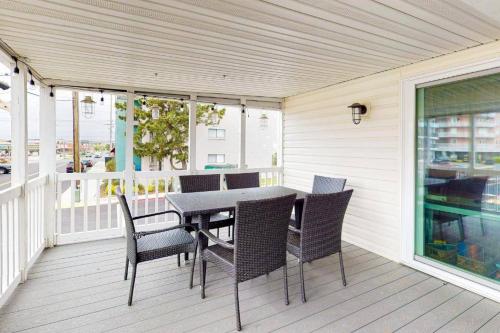 a patio with a table and chairs on a deck at The Orange Crush - 5BR Beachfront Family Retreat in Ocean City