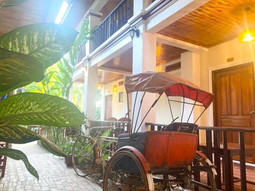 an old carriage is sitting outside of a house at Golden Sun Boutique Hotel in Luang Prabang