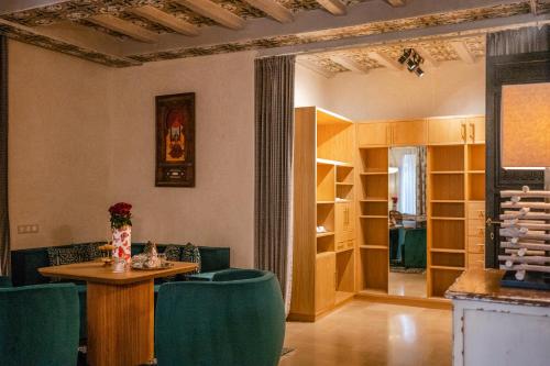 a living room with a table and green chairs at Tigmiza Boutique Hotel & Spa in Marrakech