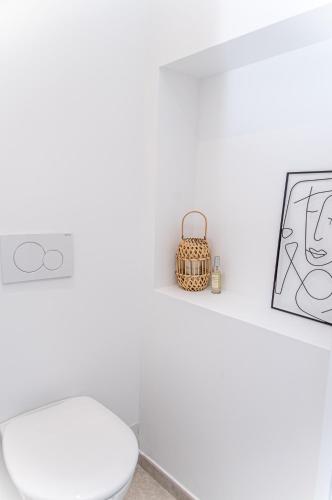 - une salle de bains blanche avec des toilettes et une photo dans l'établissement Provence - Courte ou moyenne durée, à Lançon-Provence