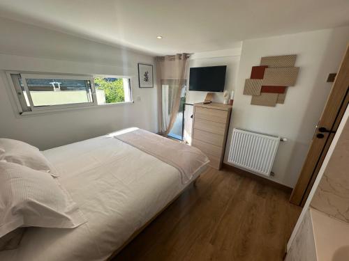 une chambre avec un lit blanc et une fenêtre dans l'établissement La Cour des Princesses, à Deauville