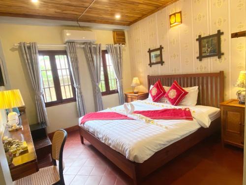 a bedroom with a bed with red pillows at Golden Sun Boutique Hotel in Luang Prabang