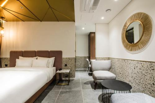 a bedroom with a bed and a mirror and a chair at Hotel the Castle Jamsil#1 in Seoul