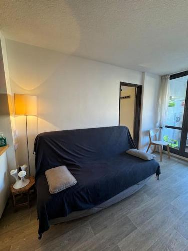 - une chambre avec un lit bleu dans l'établissement Appartement Cap d'Agde accès direct à la plage, au Cap d'Agde