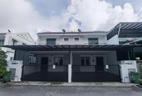 a white house with a black and white garage at Cosy 2-Storey Holiday Home Vines 2 @Pasar Malam -2 in Tanah Rata
