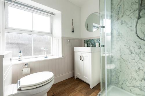 a bathroom with a toilet and a glass shower at Star Cottage - Harbottle - Nr Rothbury - Northumberland in Morpeth