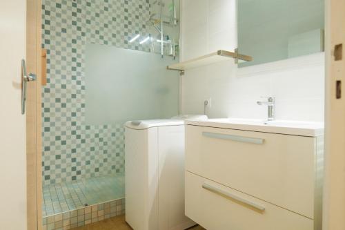 a white bathroom with a sink and a shower at Appartement proche de la plage de Tanchet, quartier des Présidents Les Sables - 6 personnes in La Rudelière