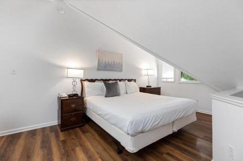 a white bedroom with a bed and two night stands at Laurelwood 25 with Wintergreen Advantage in Wintergreen
