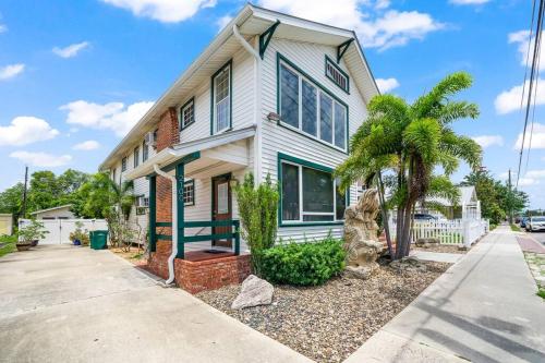 a white house with palm trees in front of it at Downtown Loft with Parking - Steps to Restaurants & Nightlife in Melbourne
