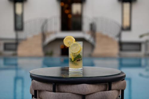 a drink with lemon slices on a table next to a pool at Onyour Dreams Belek in Belek