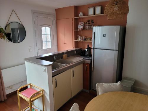 une cuisine avec un évier et un réfrigérateur dans l'établissement Appartement au cœur de Rambouillet, à Rambouillet