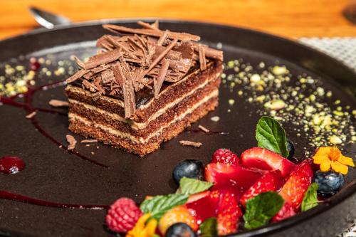 a piece of chocolate cake on a black plate with strawberries at Sheraton Guayaquil in Guayaquil