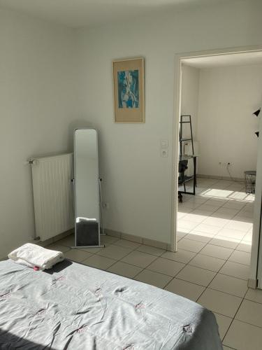une chambre avec un lit et un miroir au mur dans l'établissement T2 St Nazaire Ouest, à Saint-Nazaire