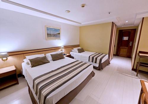 a hotel room with two beds in a room at Riale Vilamar Copacabana in Rio de Janeiro