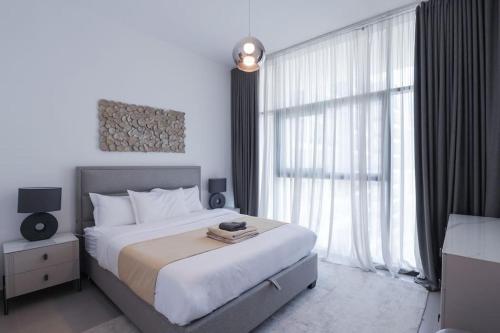 a bedroom with a large bed and a large window at Chic 1 Bedroom in Privé Residence, Dubai Hills in Dubai