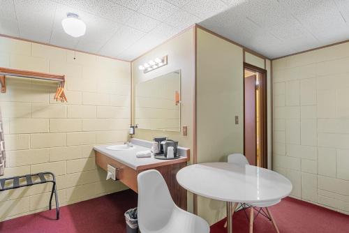 a bathroom with a sink and a table and a mirror at Cashmere Inn in Cashmere