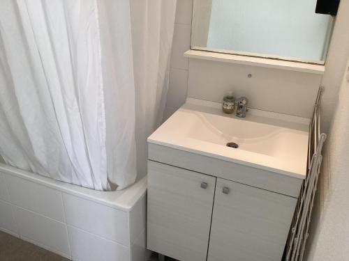 une salle de bain blanche avec un lavabo et une douche dans l'établissement T2 St Nazaire Ouest, à Saint-Nazaire