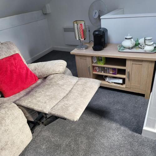 a living room with a chair and a table at House of Vecolate in Sowerby Bridge
