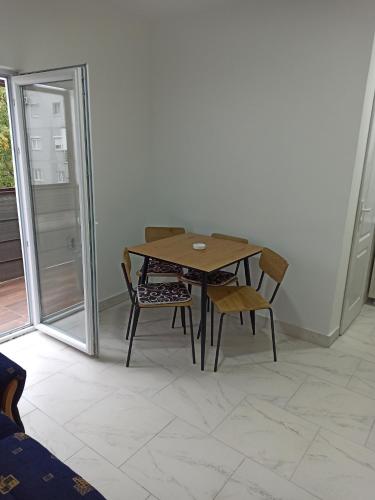a wooden table and chairs in a room with a window at Beograd, Oaza Palilula, 2 in Borča
