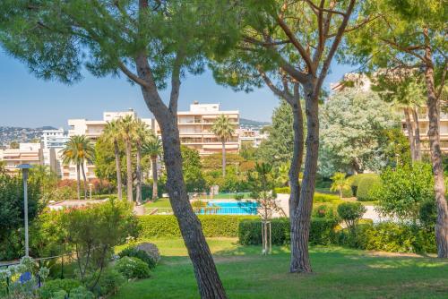 un parc avec des arbres et une piscine dans l'établissement Spacieux 3 pièces avec piscine et tennis, à Antibes