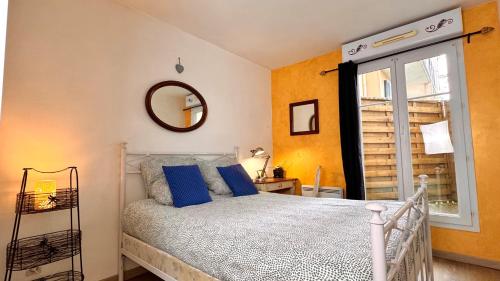 une chambre avec un lit avec des oreillers bleus et une fenêtre dans l'établissement Magnifique Appartement 9min Disney, à Bailly-Romainvilliers