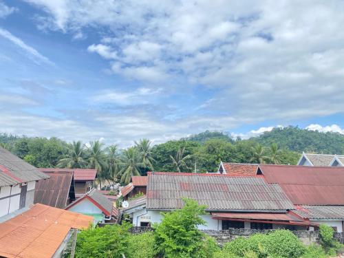 a group of houses with roofs and palm trees at Golden Sun Boutique Hotel in Luang Prabang