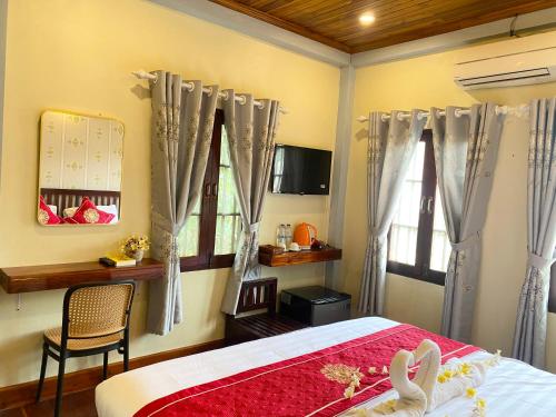 a bedroom with a bed and a window with curtains at Golden Sun Boutique Hotel in Luang Prabang