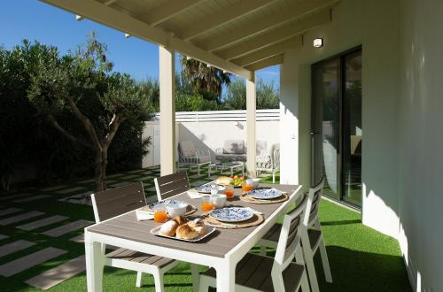 a white table with food on a patio at Villa Charme in San Vito lo Capo