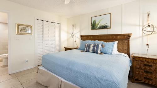 ein Schlafzimmer mit einem Bett mit einer blauen Bettdecke in der Unterkunft Modern and Coastal Ocean Pointe 2307 in Key Largo