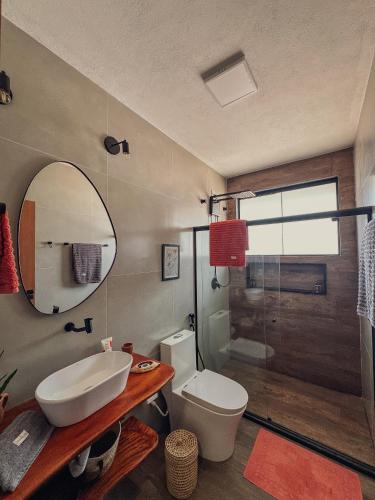a bathroom with a sink and a toilet and a mirror at La Maison Loosaï - Quarto em Pousada sem TV in Itacaré