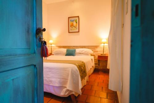 a bedroom with two beds and a blue door at Vieja Posada Hotel Histórico in Cafayate