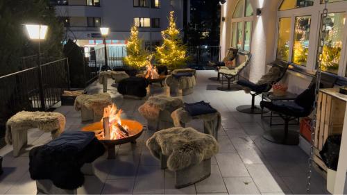 a group of tables and chairs with a fire pit at GRAND your home with common kitchens with self check-in in Engelberg