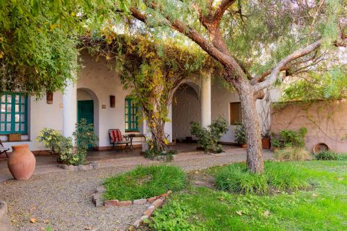 a house with a tree in the yard at Vieja Posada Hotel Histórico in Cafayate
