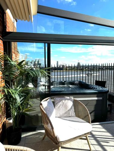 ロンドンにある3 x Bedroom Riverside Flat with HOT TUB on Roof Terraceのバルコニー(ホットタブ、椅子付)