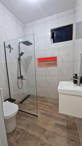 a bathroom with a shower and a toilet and a sink at Mi Refugio in San Fernando de Monte Cristi