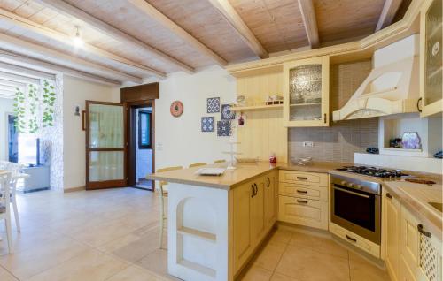 a kitchen with wooden cabinets and a stove top oven at 2 Bedroom Nice Home In Taranto in Taranto