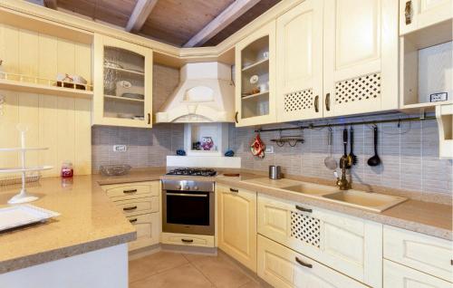 a kitchen with white cabinets and a sink at 2 Bedroom Nice Home In Taranto in Taranto