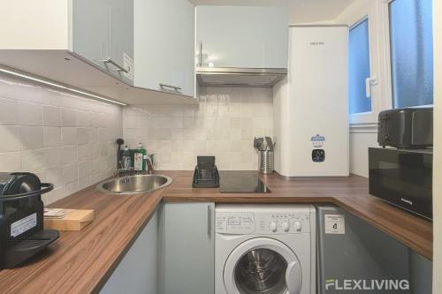 une cuisine avec une machine à laver et un évier dans l'établissement Flexliving - Studio - Martyrs, à Paris
