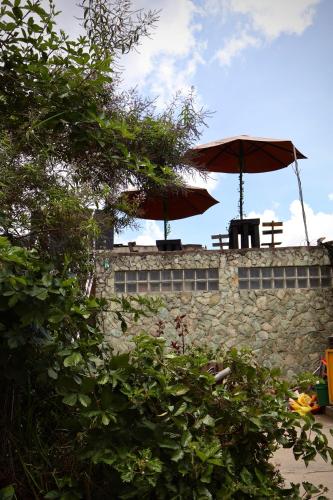 two benches and umbrellas on top of a wall at Casa I`X in Quetzaltenango