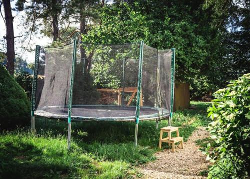 a trampoline in a net in the grass at ENJOY COZY NEST View Hills Garden Forest Sauna Hottub in Jablonné v Podještědí