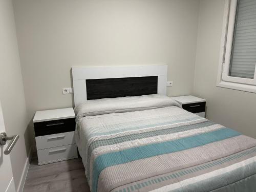 a small bedroom with a bed and two night stands at Malteses in A Guarda