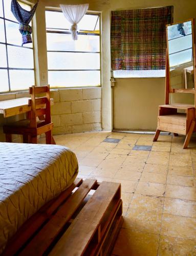 a bedroom with a bed and a table and a desk at Casa I`X in Quetzaltenango